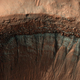 La cámara HiRISE capturó esta imagen del borde de un cráter en pleno invierno. En la pendiente del cráter que mira hacia el sur, que recibe menos luz solar, se ha formado una capa de escarcha.